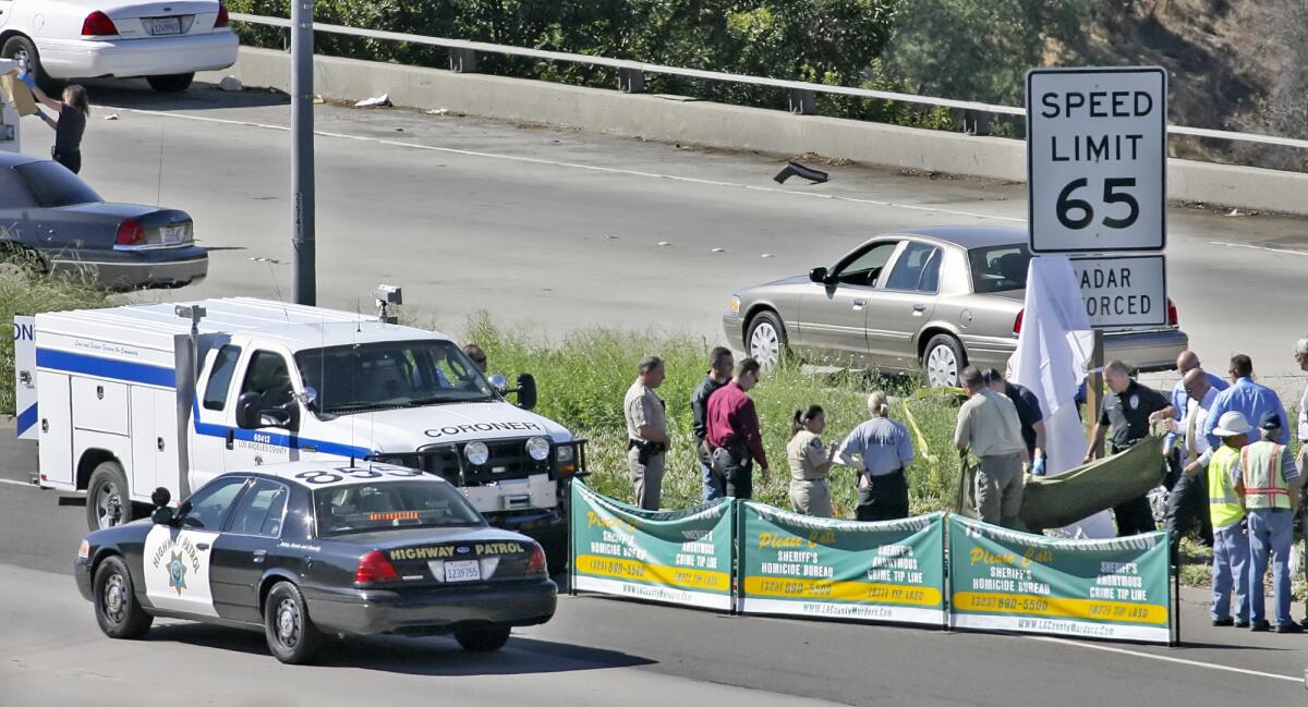 Two men were convicted this week in the 2008 murder of a Mongols Motorcycle Club member gunned down while riding on the Glendale (2) Freeway in 2008. Pictured is the L.A. County Coroner's personnel moving the victim's body on October 8, 2008.