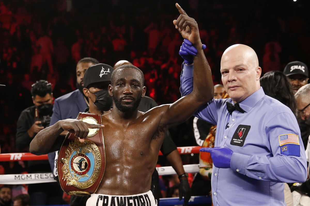 Terence Crawford poses for photographers after defeating Shawn Porter by TKO in a welterweight title boxing match, Nov. 20, 2021, in Las Vegas. There could be an undisputed and still undefeated welterweight champion in the not-so-distant future. The stage appears set for Errol Spence Jr. and Terence Crawford to finally get in the ring together. Soon after WBC and IBF champion Spence won his unification bout to take the WBA belt from Yordenis Ugás, WBO titleholder Crawford tweeted that it was time for the real fight. (AP Photo/Chase Stevens)