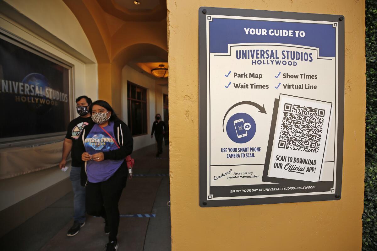 A sign at Universal Studios Hollywood has a QR code visitors can scan to download the park's app.