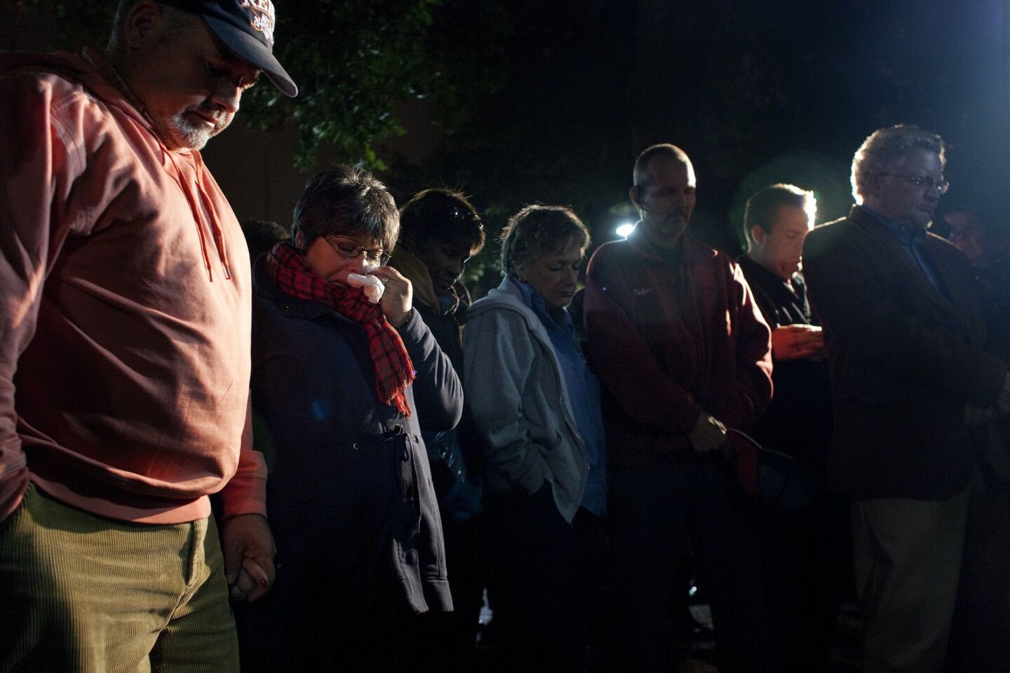 Riverside residents shed tears and pray during a vigil for the slain and wounded Riverside police officers.
