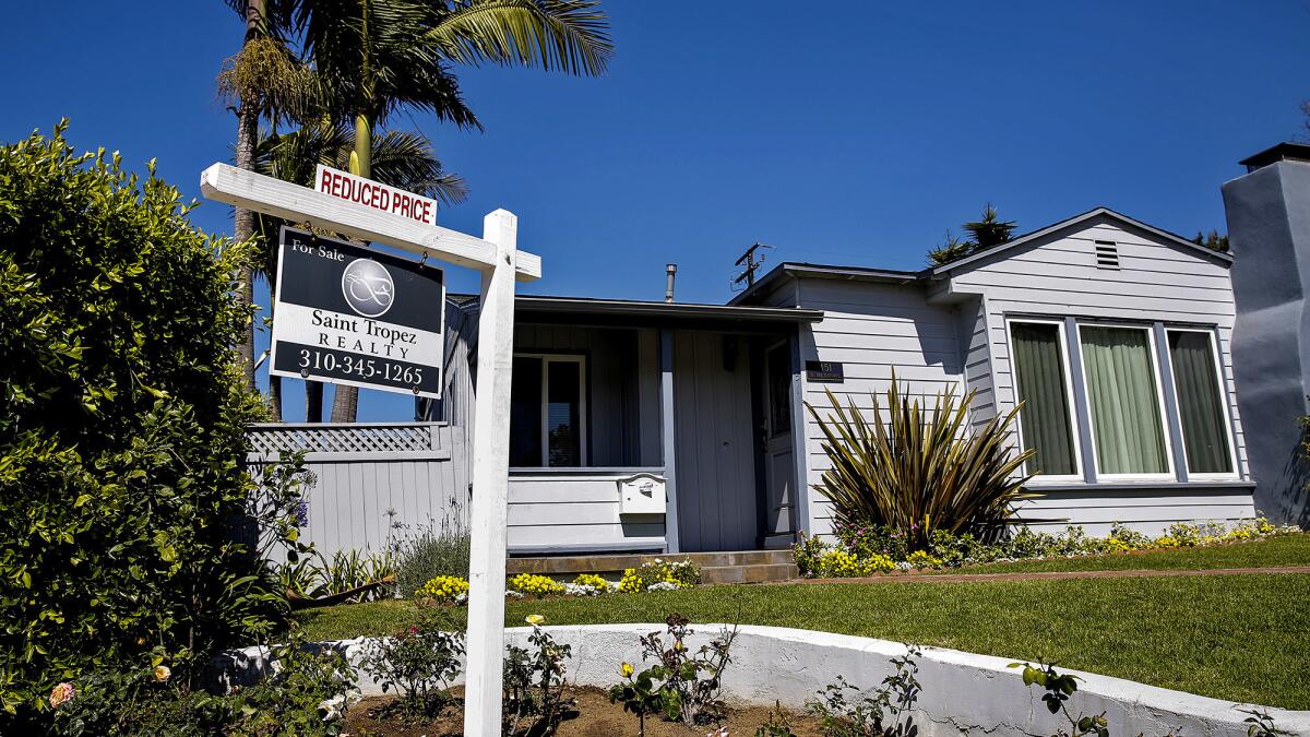 Real estate experts said they don't expect a big dropoff in demand for housing as a result of the tax bill. Above, a home for sale in Manhattan Beach in May.