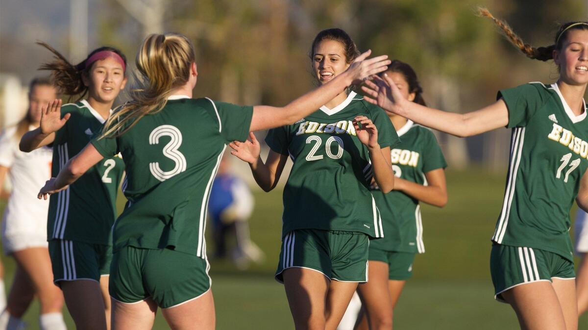 Edison High’s Michael Guptill (3) celebrates with teammates after scoring on a corner kick during the first half against Cypress in an Excalibur tournament match at Irvine Great Park.