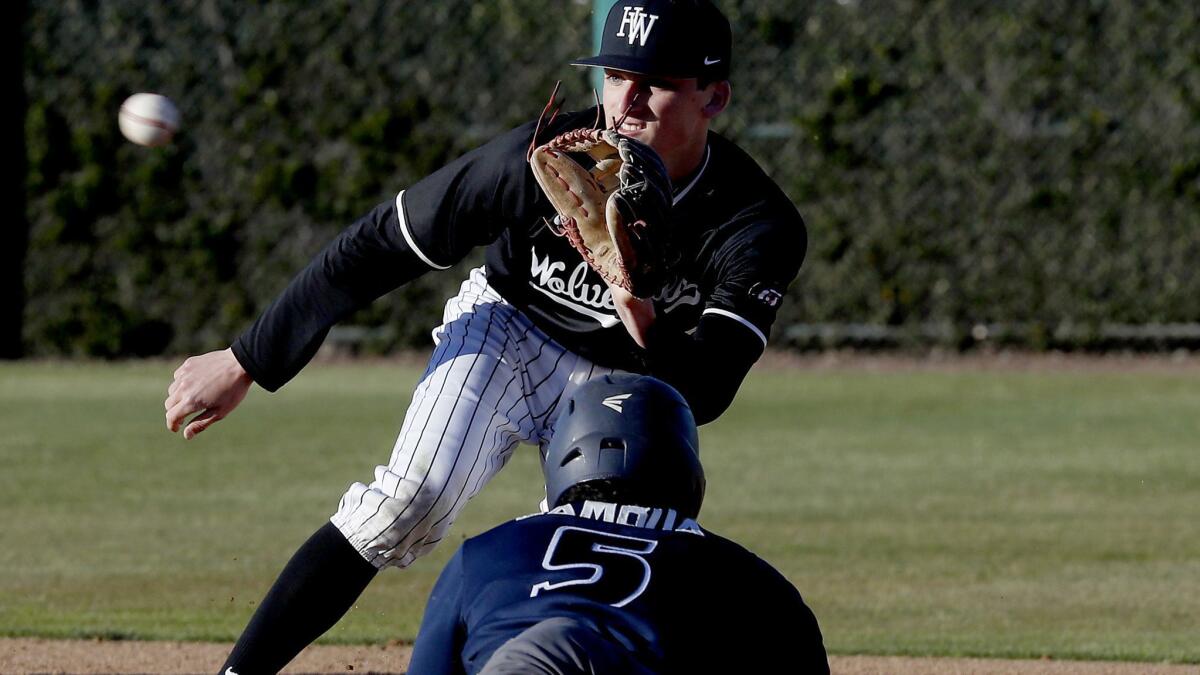 Harvard-Westlake shortstop Tyler Cox prepares to receive a throw and tag out Birmingham pinch-runner Daniel Gamboa a game between top-25 opponents on Feb. 19.