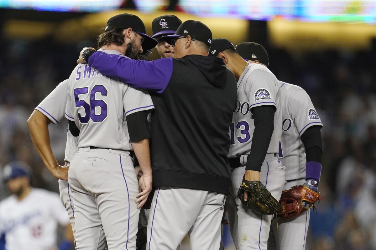 Colorado Rockies pitching coach Darryl Scott, center, talks to relief pitcher Chad Smith during the seventh inning.