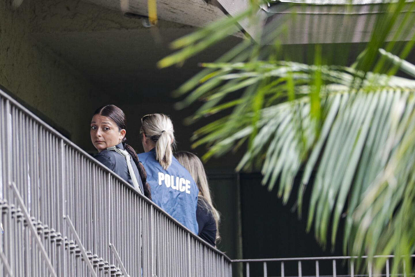 Police investigators work at the Casa De Portola apartment complex in Garden Grove, where two people were fatally stabbed.