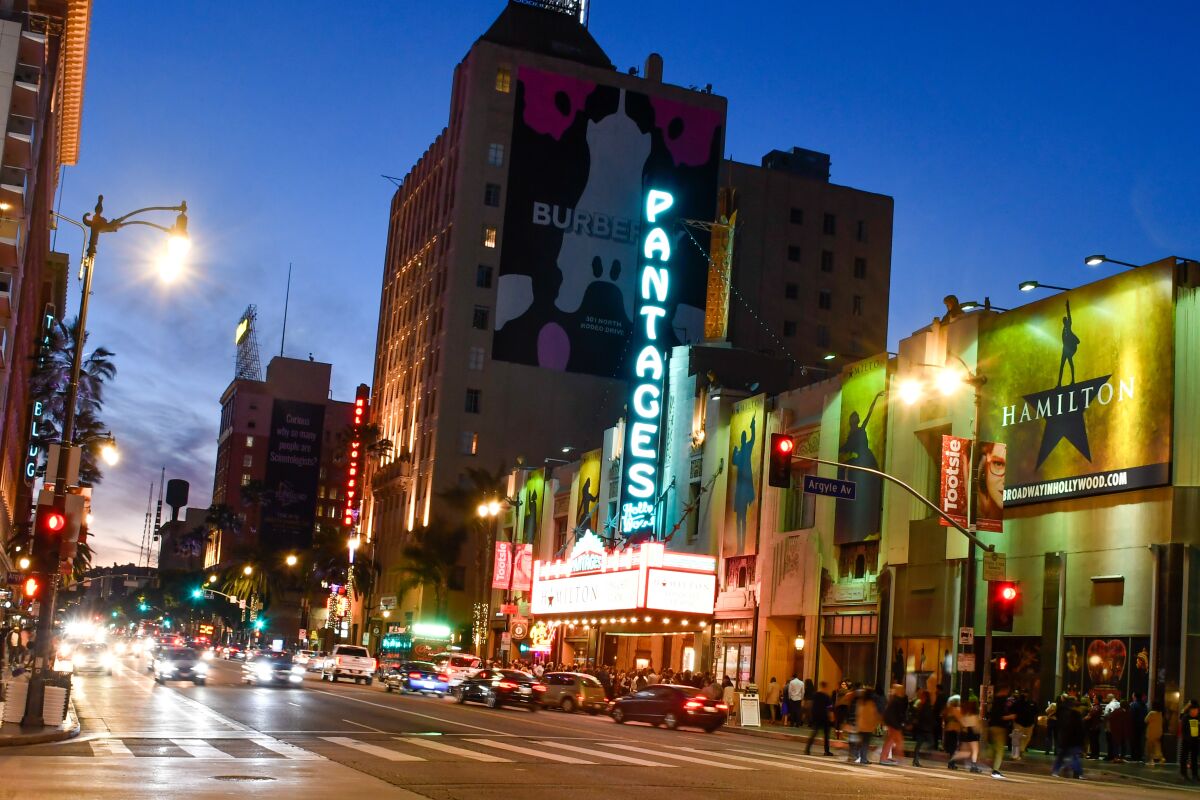 Exterior of The Pantages Theater on Hollywood Boulevard with its neon sign and "Hamilton" posters
