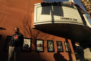 PASADENA, CA - FEBRUARY 2, 2022 - - Pedestrians walk past the Laemmle Theatre's Playhouse 7 featuring a blank marquee in Pasadena on February 2, 2022. The Laemmle Theatre's Playhouse 7, which opened February 5, 1999, was the first arthouse movie theater chain in Los Angeles. After 23 years in business it will close its doors this year. At present it is still open. (Genaro Molina / Los Angeles Times)