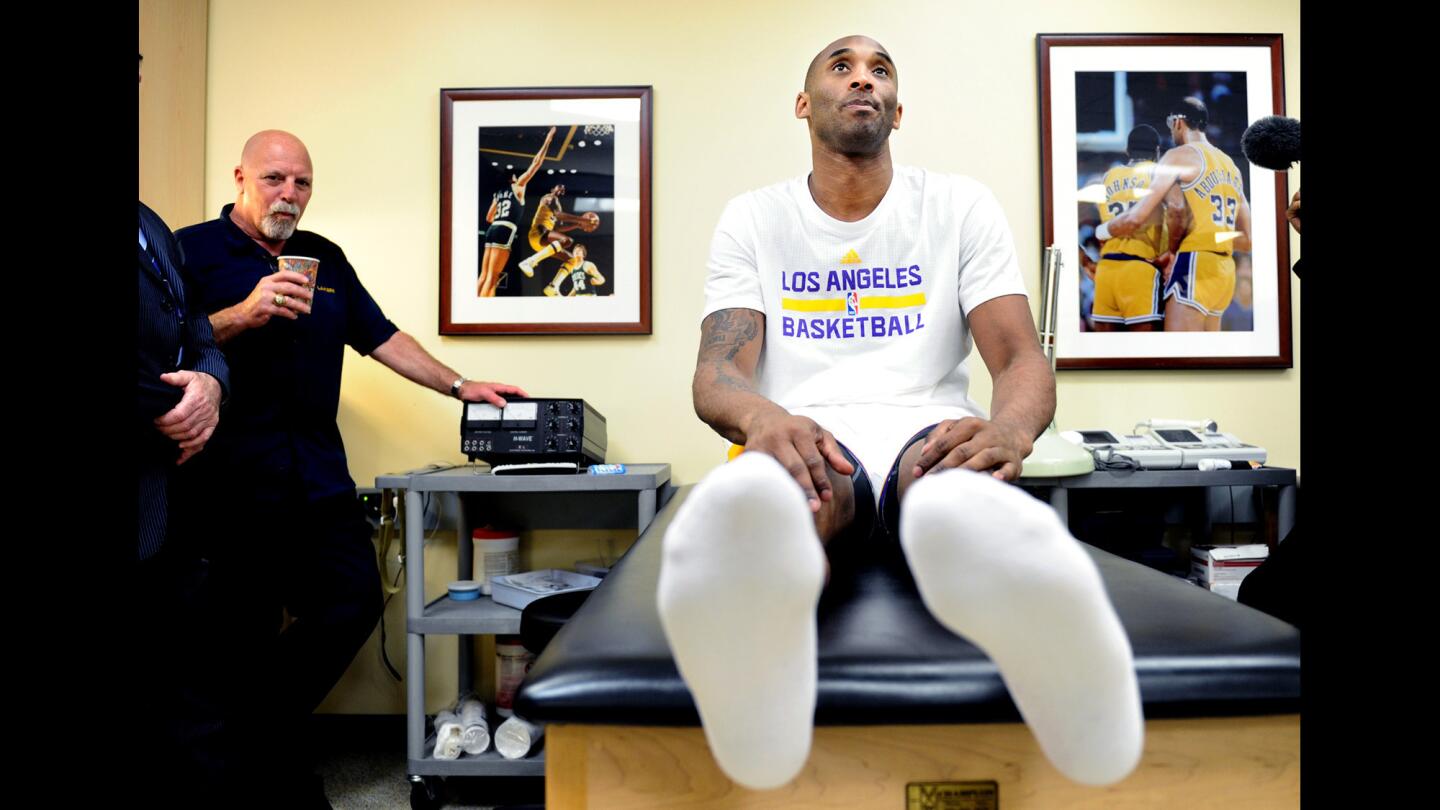 Lakers Kobe Bryant sits on the trainer's table while going through a stretching exercise before a game with the Knicks at the Staples Center.