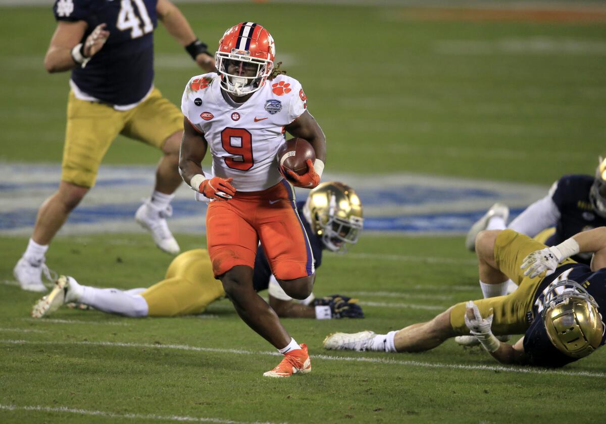 Clemson running back Travis Etienne runs with the ball during a game.