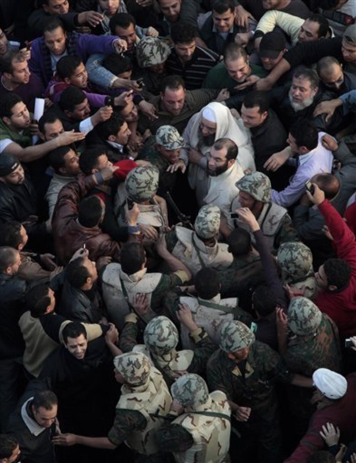 Soldiers surround an unidentified Muslim cleric, center in white, in Tahrir, or Liberation, Square in Cairo, Egypt, Tuesday, Feb. 1, 2011. More than a quarter-million people flooded into the heart of Cairo Tuesday, filling the city's main square in by far the largest demonstration in a week of unceasing demands for President Hosni Mubarak to leave after nearly 30 years in power. (AP Photo/Lefteris Pitarakis)