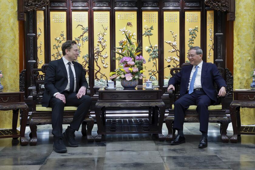 In this photo released by Xinhua News Agency, visiting Tesla founder and CEO Elon Musk, left, meets with Chinese Premier Li Qiang in Beijing, Sunday, April 28, 2024. Musk met with a top government leader in the Chinese capital Sunday, just as the nation's carmakers are showing off their latest electric vehicle models at the Beijing auto show. (Wang Ye/Xinhua via AP)