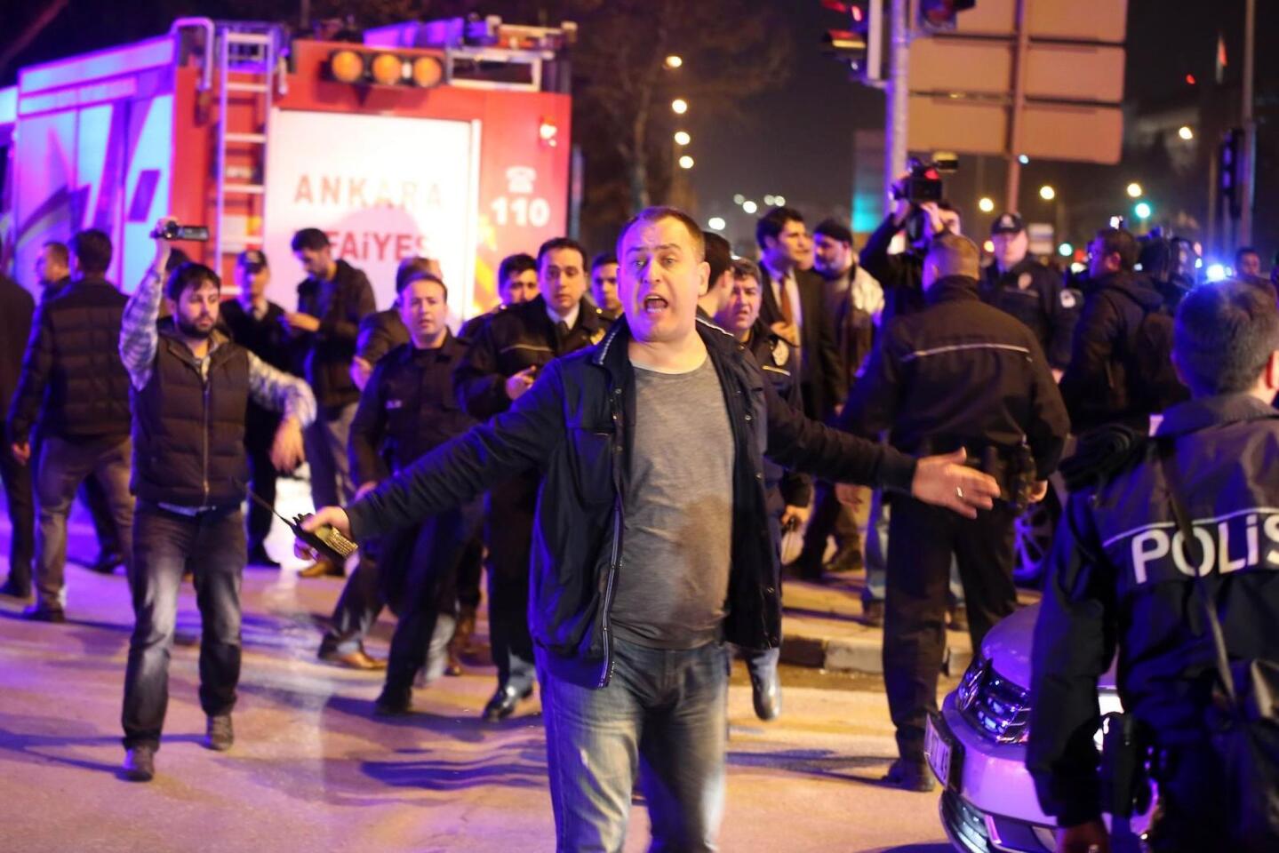 People react at the scene of a car bomb that went off late Wednesday during rush hour in Ankara, Turkey's capital, near a convoy of buses carrying military personnel.