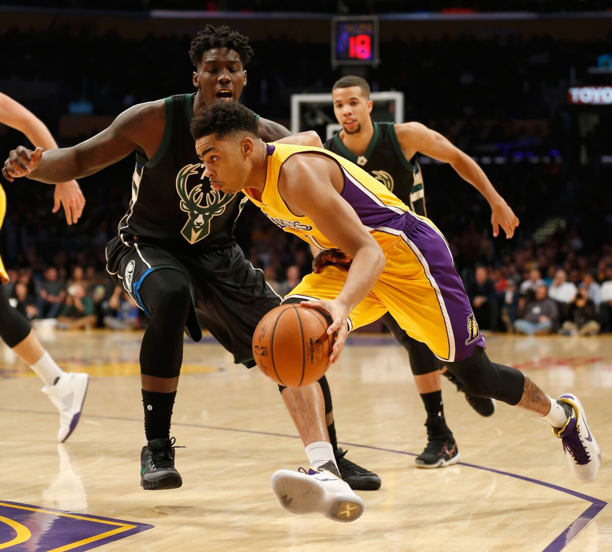 Lakers' D'Angelo Russell dribbles past Milwaukee's Johnny O'Bryant III during the first half of a game at Staples Center on Tuesday.