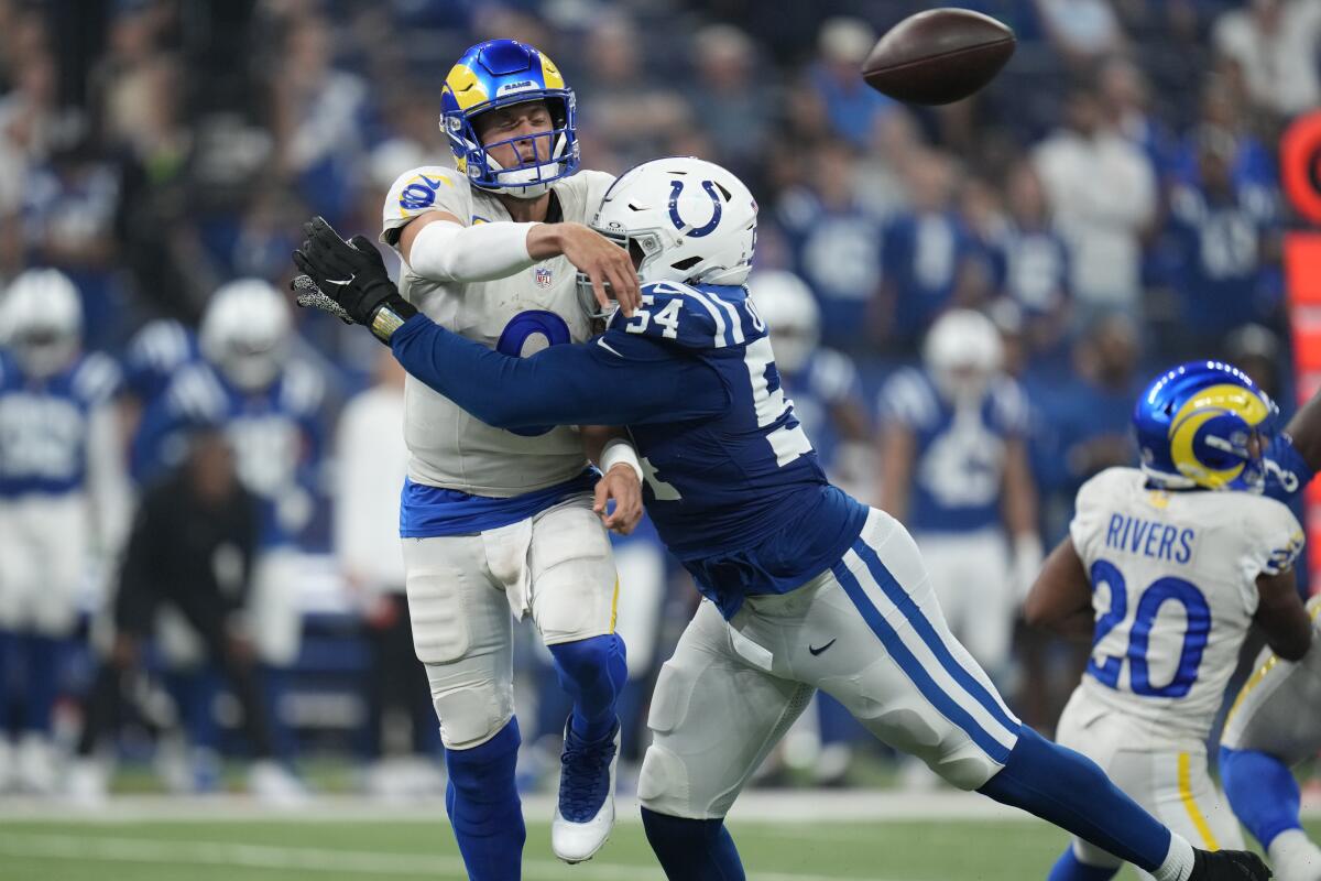 Rams quarterback Matthew Stafford throws the ball as he is hit by  Colts defensive end Dayo Odeyingbo.