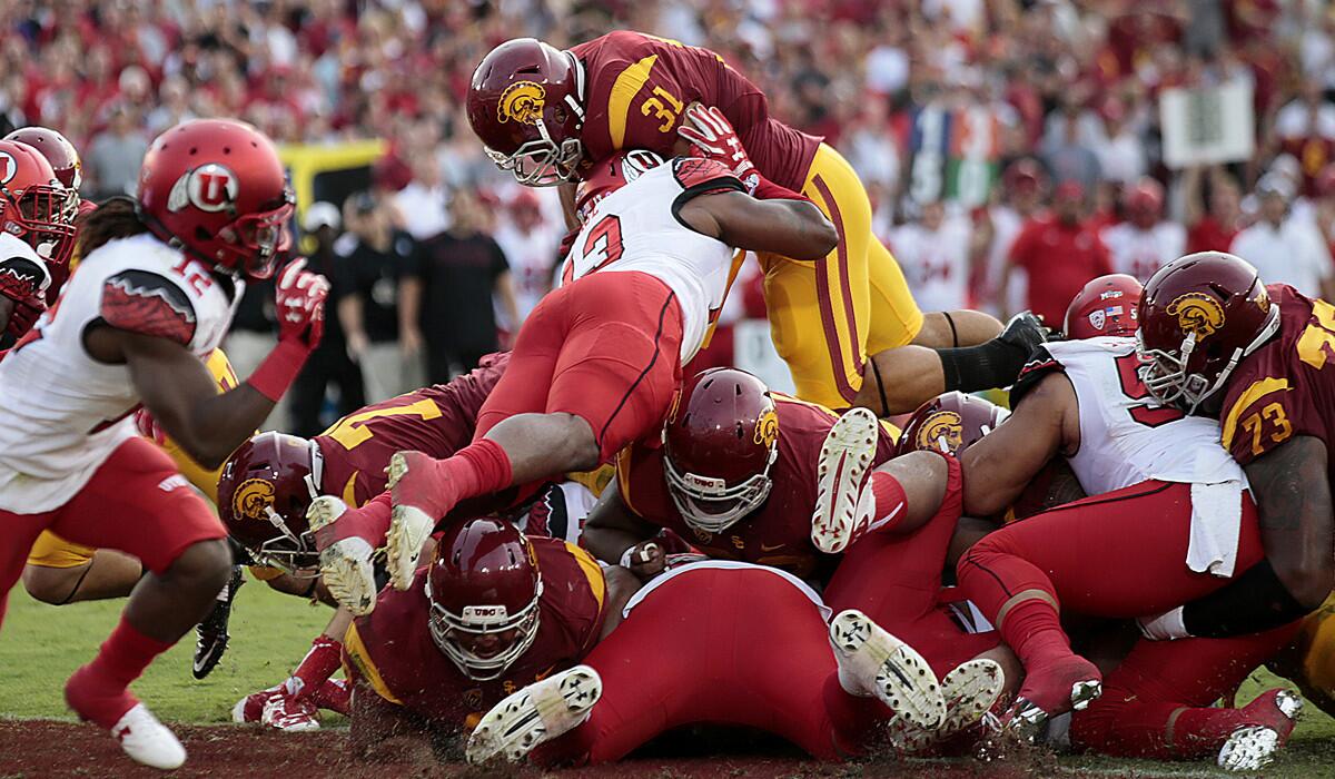 USC fullback Soma Vainuku dives over the pile for a second-quarter touchdown against Utah at the Los Angeles Memorial Coliseum on Saturday.