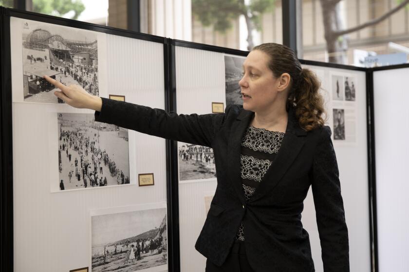 San Diego, CA - October 04: Anne Miggins, archive supervisor, talks about swimsuits in an image during the opening of a new exhibit called Roaring San Diego which displays items from the 20s in the City Administration Building on Tuesday, Oct. 4, 2022 in San Diego, CA. (Ana Ramirez / The San Diego Union-Tribune)