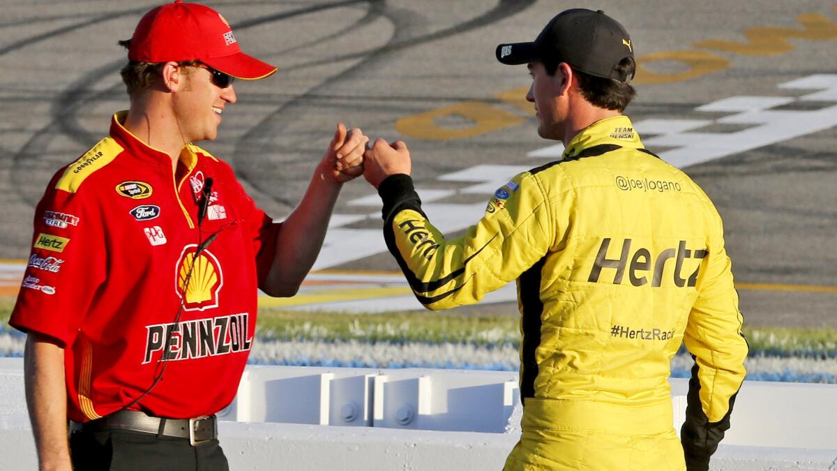 Joey Logano, right, fist-bumps a crew member Friday after qualifying on the pole for Saturday's NASCAR Sprint Cup race at Richmond International Raceway.
