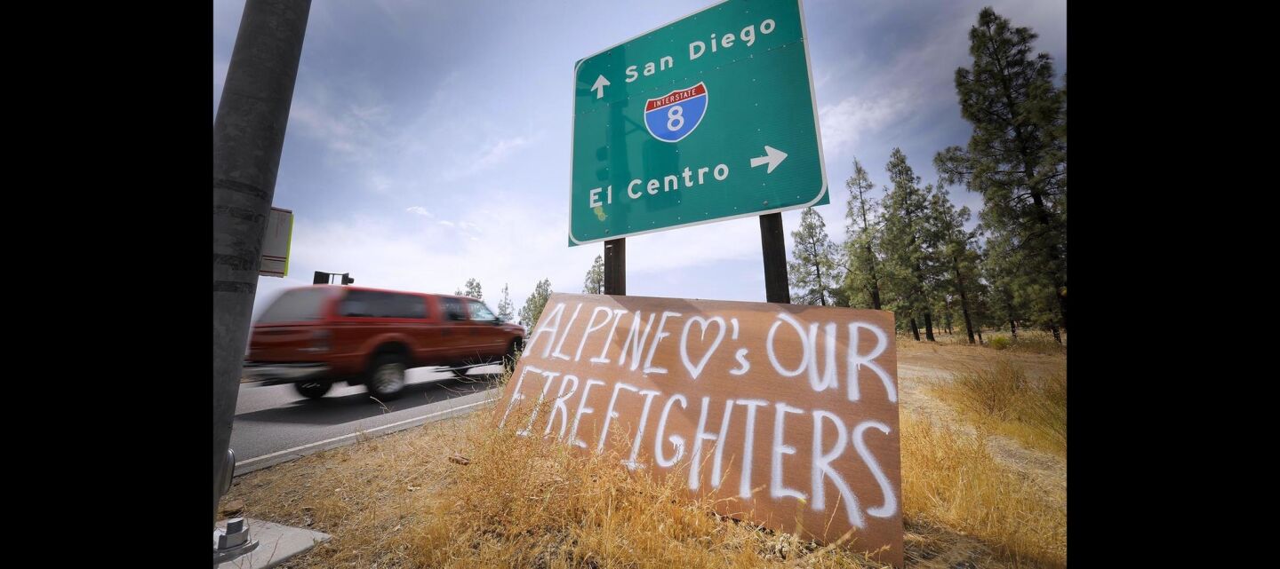 A sign thanking firefighters for their work to save homes during the West Fire in Alpine leans against the Interstate 8 sign at Tavern Road.