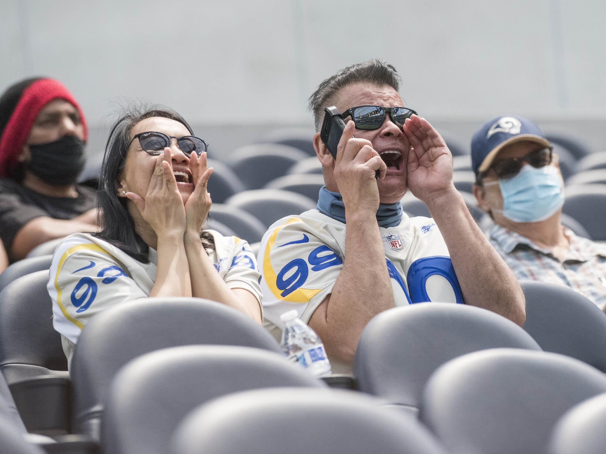 Rams season ticket holders Jamella and Steve Munoz sit in their seats for the first time at SoFi Stadium in Inglewood.