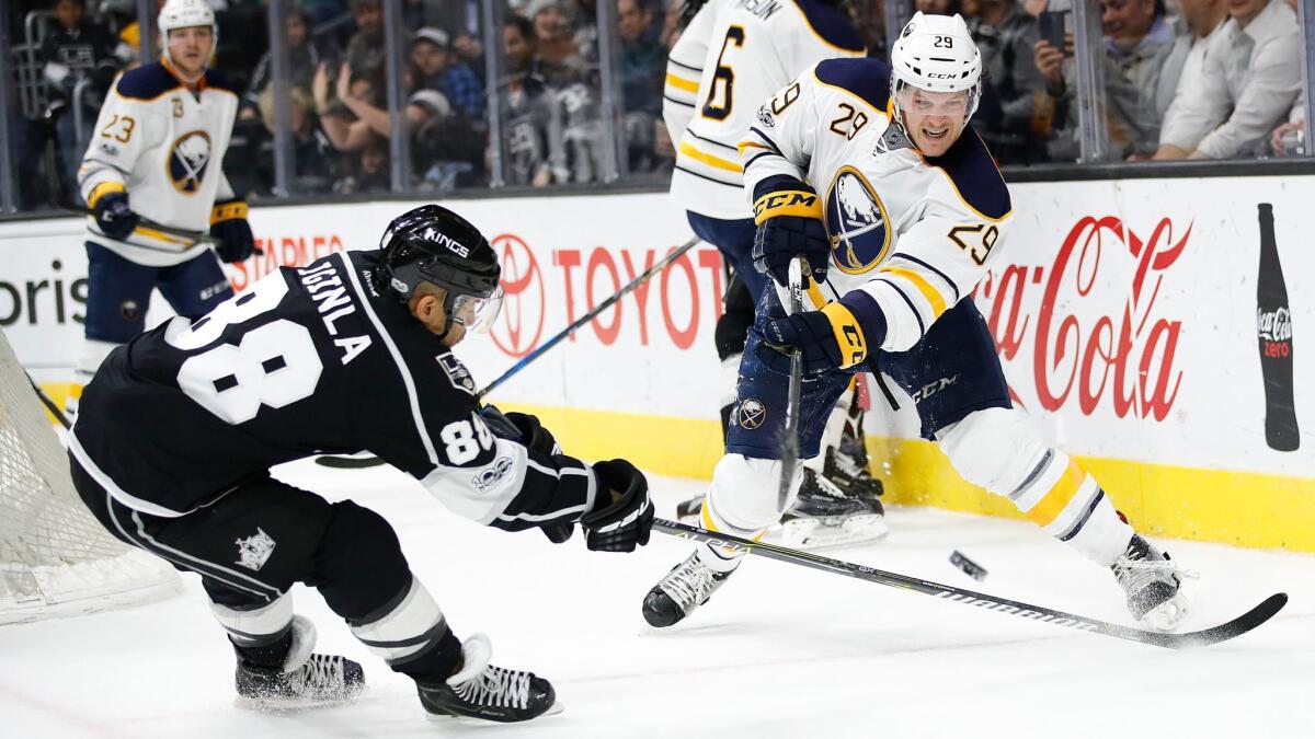 Buffalo's Jake McCabe, right, passes the puck as the Kings' Jarome Iginla defends.