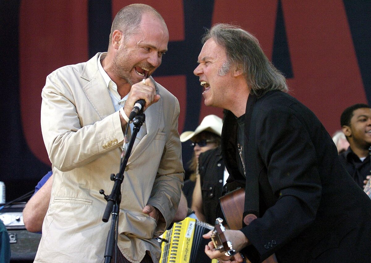Gord Downie, left, of the Tragically Hip performs with Neil Young in Barrie, Canada, in 2005.