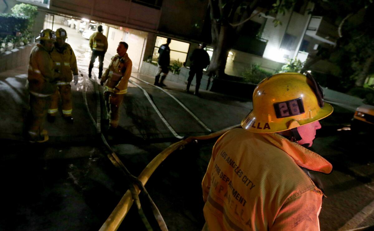 Los Angeles firefighters mop up after putting out an apartment fire on South Hobart Boulevard in Koreatown.