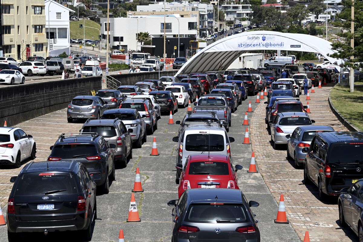 Lines of cars are seen as people wait to get a COVID-19 test at the St Vincent's Hospital Drive testing clinic at Bondi Beach in Sydney, Wednesday, Dec. 15, 2021. Australia’s New South Wales state set a record for new COVID-19 cases on Thursday, its highest daily total since the pandemic began. (Bianca De Marchi/AAP Image via AP)
