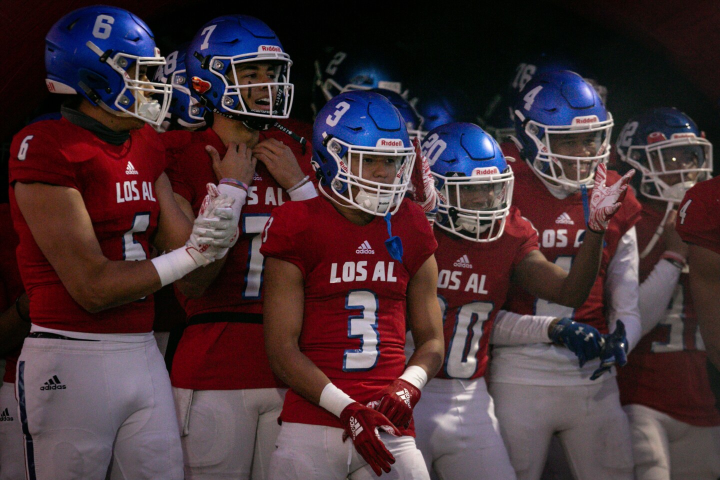 LOS ALAMITOS, CA - MARCH 12: Los Alamitos football team enter the field for their first game of the season against Millikan on Friday, March 12, 2021. (Jason Armond / Los Angeles Times)