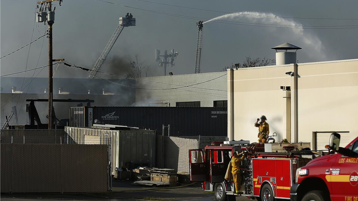 Firefighters monitor a blaze which was burning inside a plastics recycling company as a water cannon is used to help put it out.
