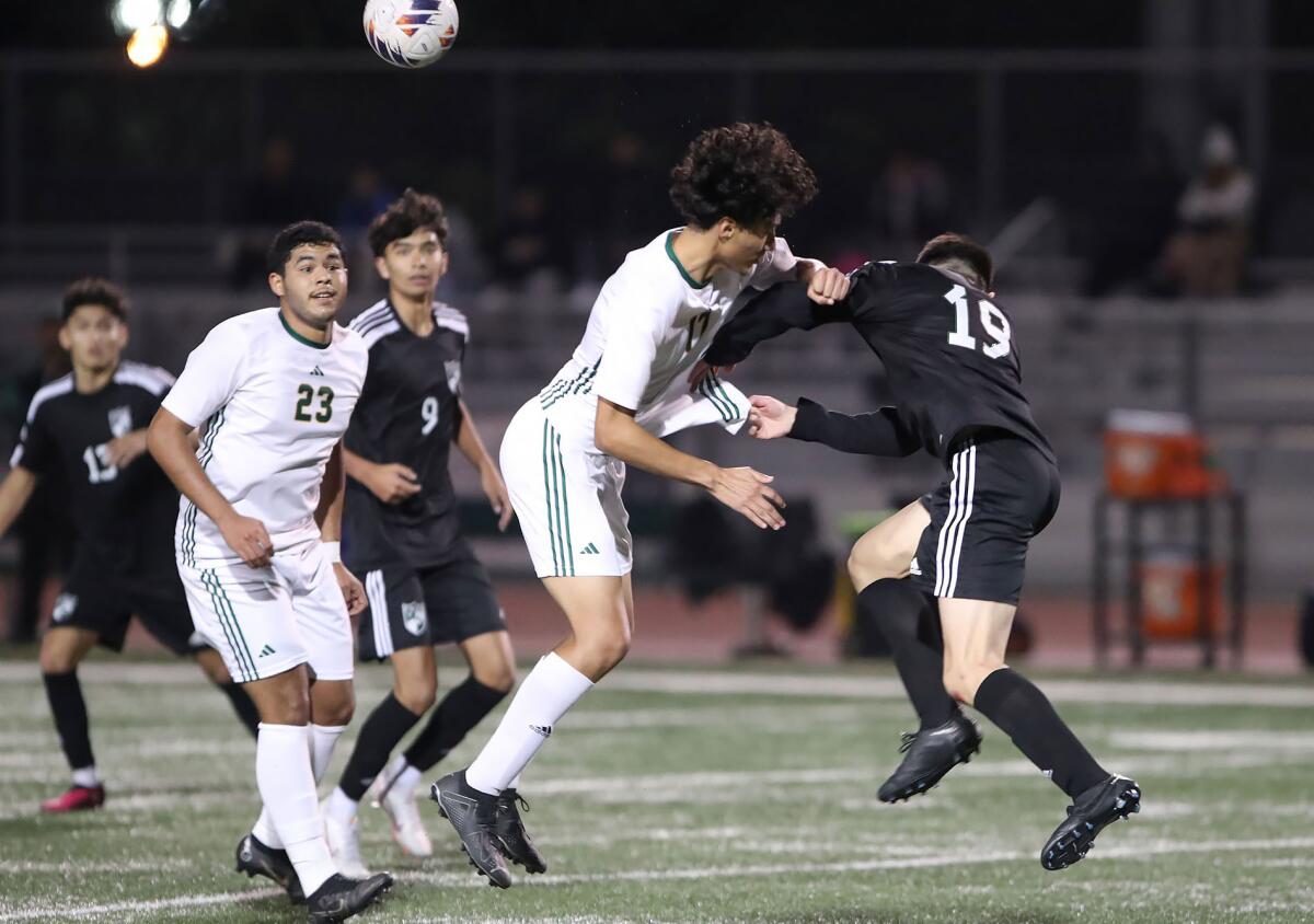 Costa Mesa's Noe Martinez (19) collides with Saddleback's Isaiah Ortiz as they battle for a high ball on Friday.