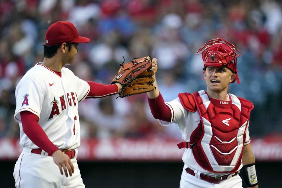 Angels pitcher Shohei Ohtani taps gloves with Max Stassi.