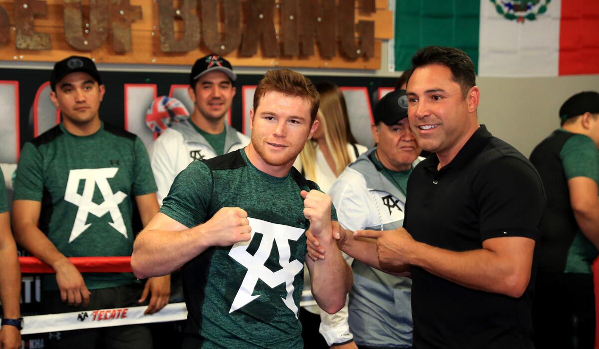 Saul "Canelo" Alvarez, left, poses with Oscar De La Hoya during a media workout.