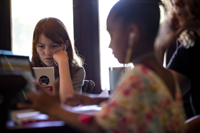 Students do homework at the kitchen table in home schooling session during the COVID-19 pandemic.