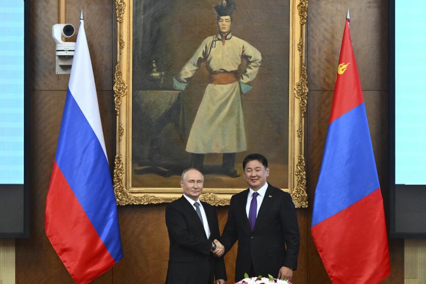 Russian President Vladimir Putin, left and Mongolian President Ukhnaagiin Khurelsukh shake hands as they pose for photos prior to the Russian-Mongolian talks at the Saaral Ordon Government Building in Ulaanbaatar, Mongolia, Tuesday, Sept. 3, 2024. (Kristina Kormilitsyna, Sputnik, Kremlin Pool Photo via AP)