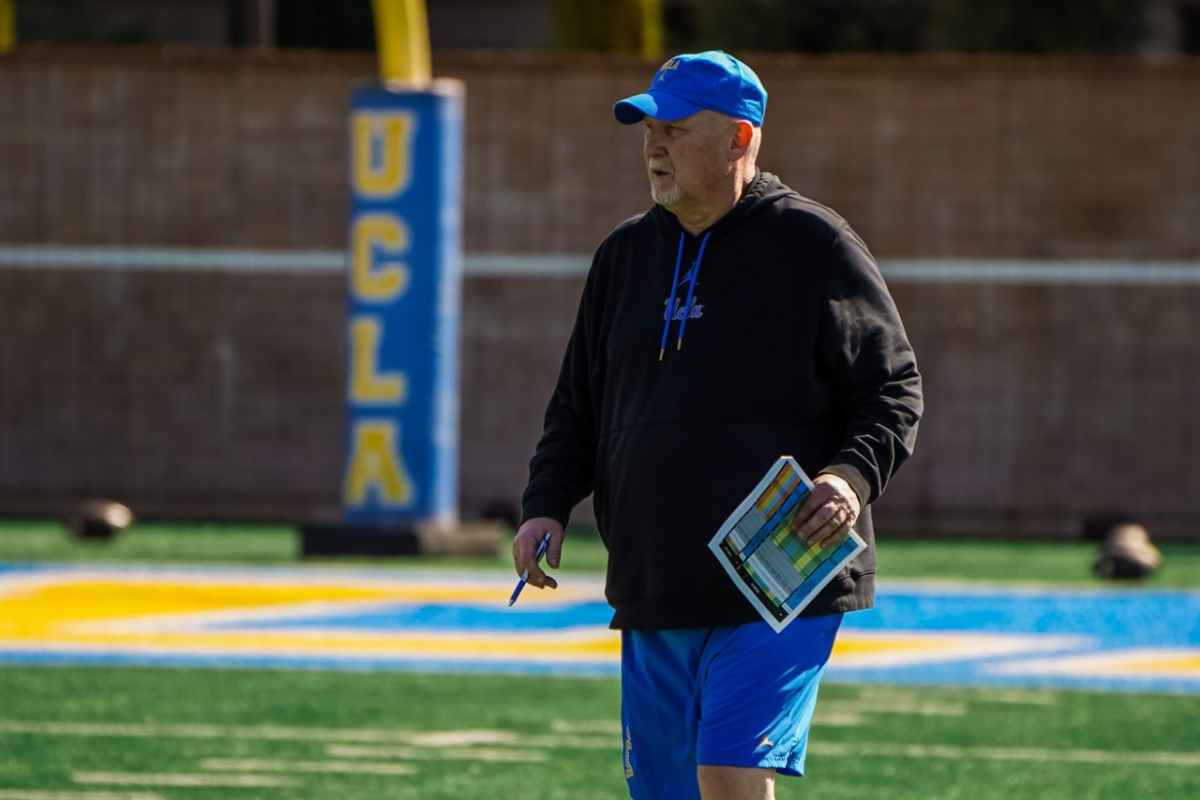 UCLA defensive coordinator Bill McGovern walks on a practice field.