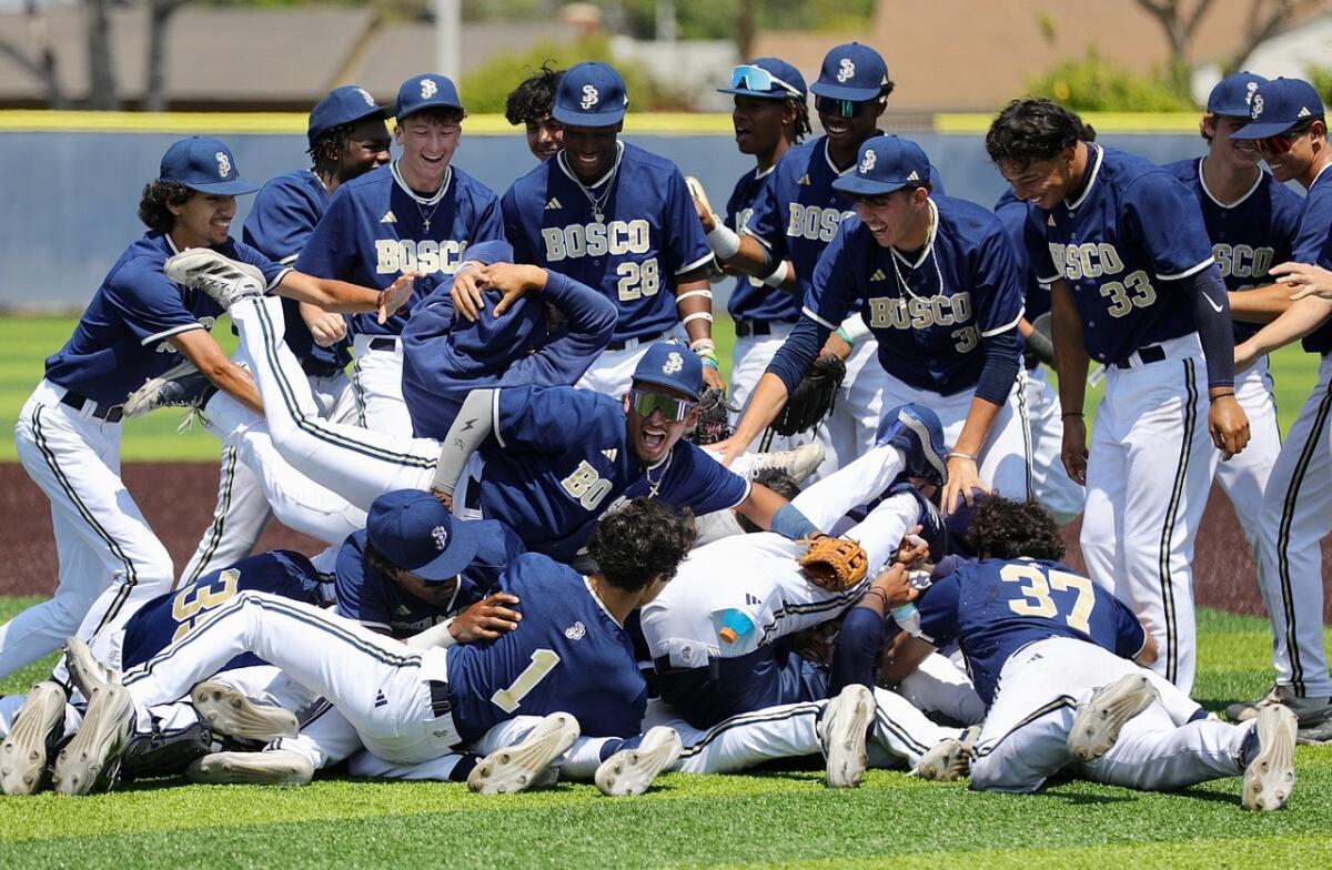 St. John Bosco High teammates celebrate with a dogpile on the field after winning the regional baseball title.