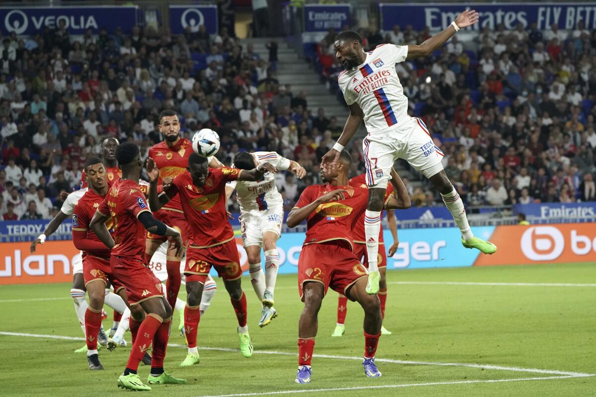 Lyon's Karl Toko Ekambi, right, heads the ball during the French League One soccer match between Lyon and Angers in Decines, near Lyon, central France, Saturday, Sept. 3, 2022. (AP Photo/Laurent Cipriani)