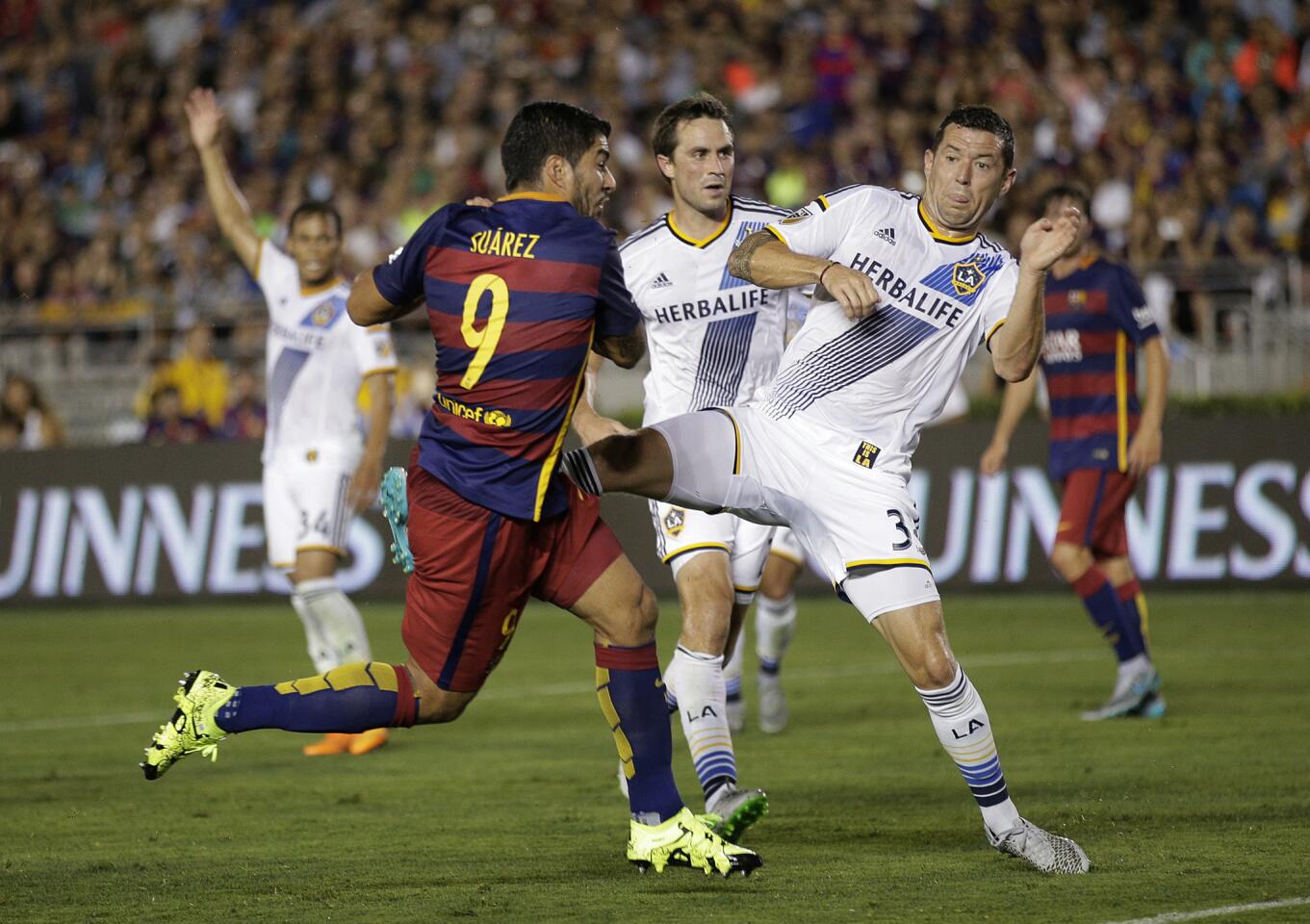 FC Barcelona's Luis Suarez, left, shoots to score as he is defended by Los Angeles Galaxy's Dan Gargan during the first half of an International Champions Cup soccer match Tuesday, July 21, 2015, in Pasadena, Calif. (AP Photo/Jae C. Hong)