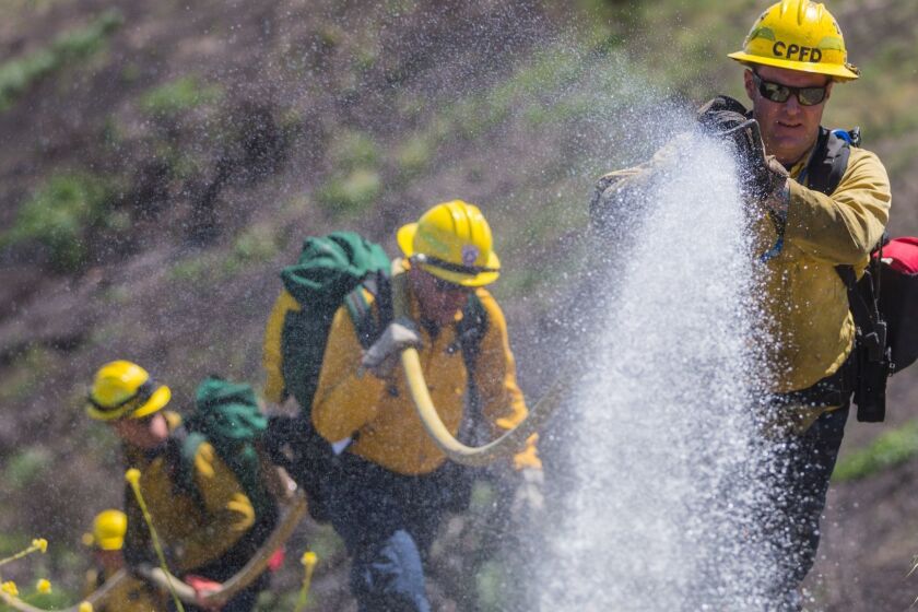 Firefighter Mark Williams, Station 4, Camp Pendleton Fire Department, douses a simulated fire while conducting wild land fire refresher training 130 (WRT) at a mutual threat zone, April 16, 2018. The annual training, held every spring, revolves around a simulated wildfire that firefighters must work together to contain. After the drill, participants discussed which elements went well as well as areas for improvement to ensure readiness for the upcoming fire season. (U.S. Marine Corps photo by Lance Cpl. Kerstin Roberts)