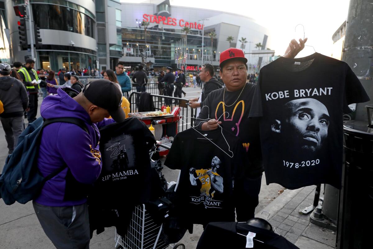 A street vendor in front of Staples Center sells Kobe Bryant memorial T-shirts.