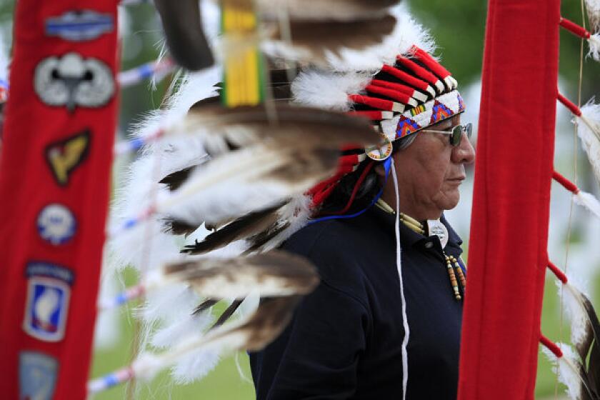 Francis Whitebird of the Sicangu Lakota Warriors leads people to the Committal Shelter during services for Lakota code talker Clarence Wolf Guts at the Black Hills National Cemetery outside Sturgis, S.D. Wolf Guts was the last living Lakota code talker. American Indians who sent coded messages to shield U.S. military communications from the enemy during World Wars I and II are being honored this week in Washington.