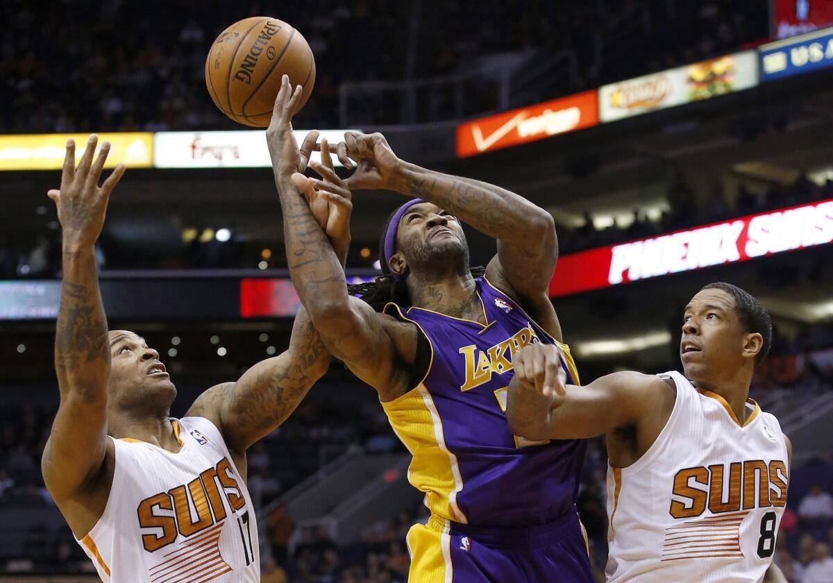 Lakers center Jordan Hill, middle, loses control of the ball while under pressure from Phoenix Suns teammates P.J. Tucker, left, and Channing Frye during the first half of Wednesday's game.