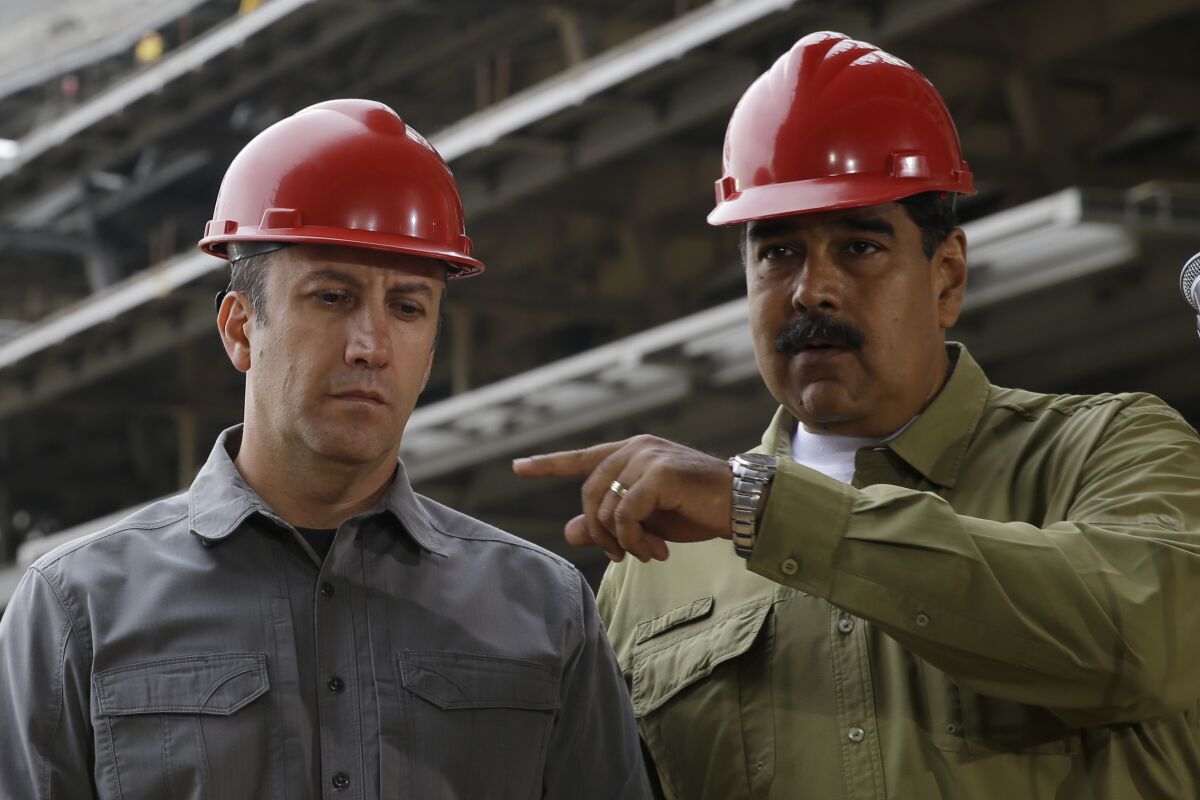 FILE - In this May 19, 2018 file photo, Venezuela's President Nicolas Maduro, right, and then Vice President Tareck El Aissami tour the construction site of La Rinconada baseball stadium on the outskirts of Caracas, Venezuela. The prosecution of El Aissami, Venezuela’s Oil Minister, for violating U.S. sanctions has run into another snag after a federal judge on Monday, Nov. 2, 2020, allowed one of his co-defendants to withdraw a guilty plea over allegations U.S. attorneys withheld evidence in the case. (AP Photo/Ricardo Mazalan, File)