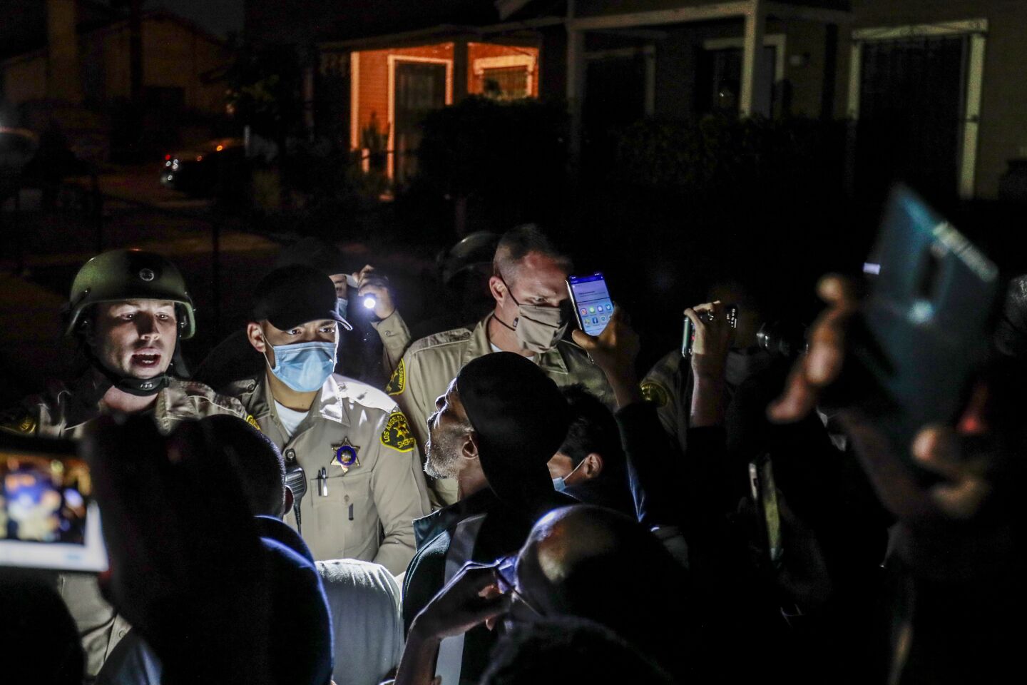 Protesters angrily confront deputies in South L.A. near the site of the shooting.