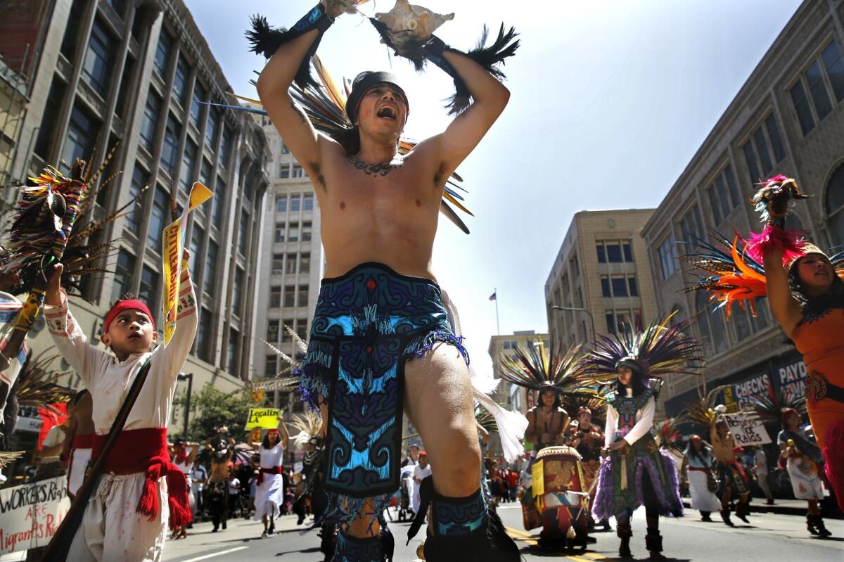 Costumed members of the Danza Mexica Cuauhtemoc political Aztec dance group perform on Broadway in downtown L.A. earlier this month.
