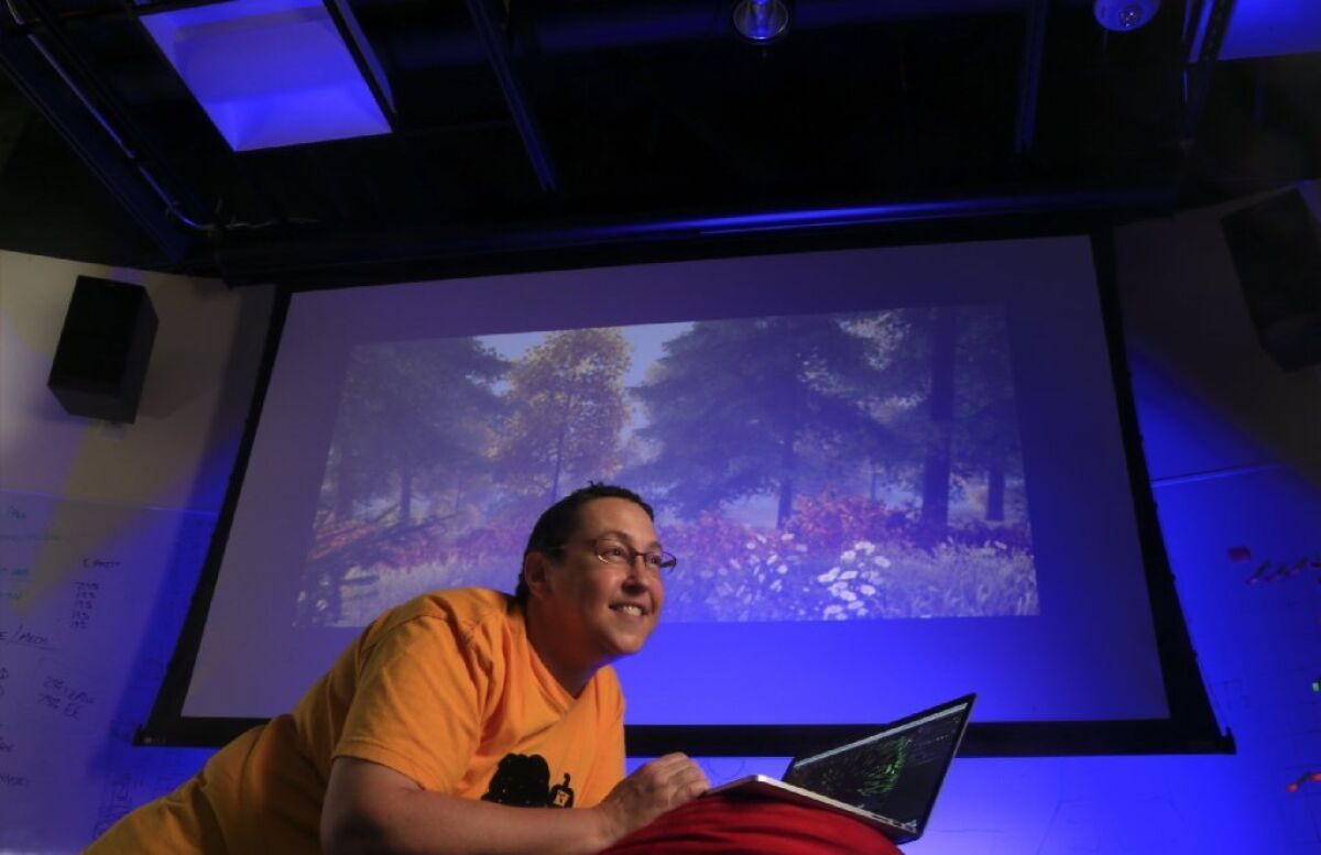 USC professor Tracy Fullerton has won a $100,000 grant from the NEH to help her develop the game "Walden," shown on screen, that puts the player in Thoreau's shoes at Walden Pond.