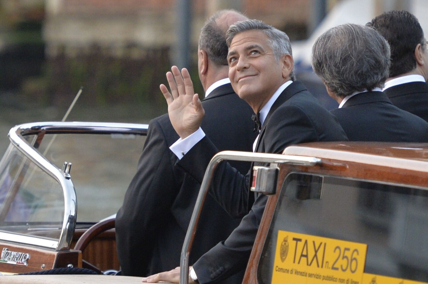 George Clooney waves to fans from the water taxi taking him from the Hotel Cipriani to the venue where he'll marry Amal Alamuddin on Saturday night.