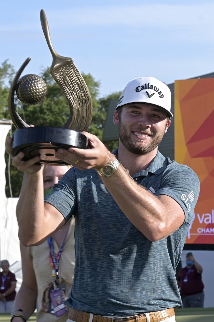 Sam Burns holds the championship trophy after winning the Valspar Championship golf tournament, Sunday, May 2, 2021, in Palm Harbor, Fla. (AP Photo/Phelan M. Ebenhack)
