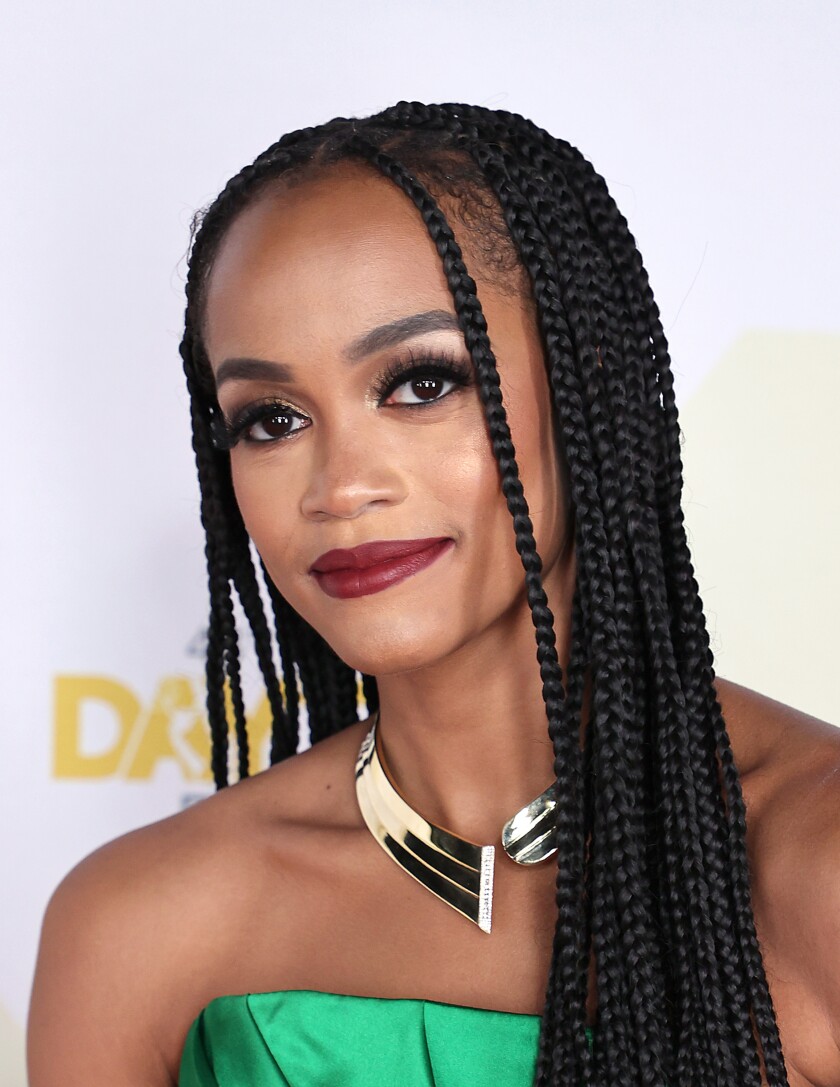 Rachel Lindsay with long braids, a strapless green gown and a silver necklace