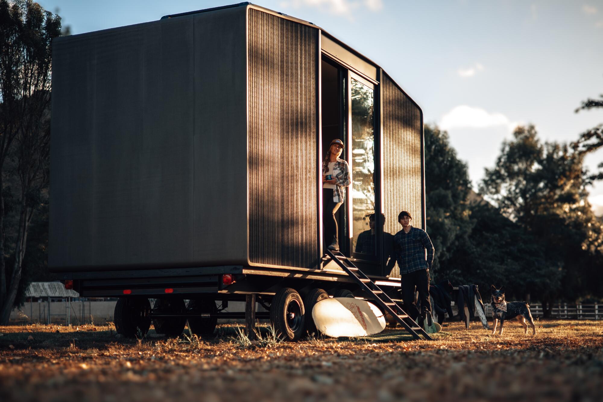 A boxy studio with sliding glass door sits on a wheeled platform.